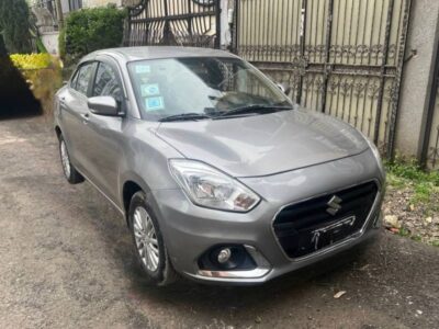 Image 2 (Front Three-Quarter View): Front three-quarter view of Silver 2022 Suzuki Dzire sedan showing front grille and headlights