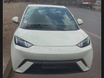 Image 2: Front angle view of 2024 BYD Seagull Dolphin Mini highlighting headlights, front bumper, and Warm Sun White paint
