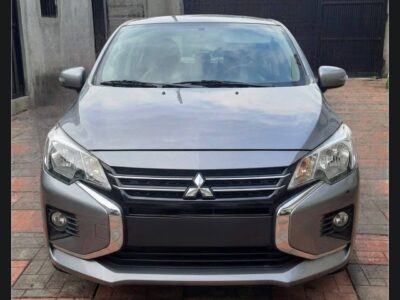 Image 1 (Front View): Front profile of 2022 Mitsubishi Attrage in Titanium Grey Metallic with Dynamic Shield chrome grille parked in Addis Ababa.