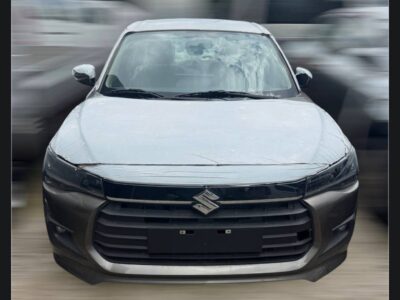 Image 3 (SUZUKI Dzire GLX (Tours) (4).jpg): Alt Text: Front view of brand new 2025 Suzuki Dzire Smart Hybrid with protective transit wrap on hood