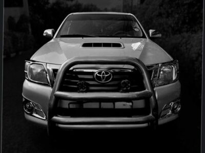 Image 1: Front view of the 2012 Toyota Hilux Vigo showing the chrome-slatted grille and heavy-duty front bull bar in Addis Ababa