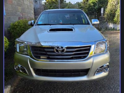 Image 2: Direct front view showing the chrome grille and hood scoop of the 2012 Toyota Hilux Vigo