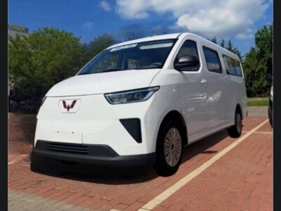 1:Front three-quarter view of new white Wuling Yangguang EV passenger van parked on paved lot in Addis Ababa